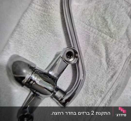 ברז מתכת מונח על מגבת לבנה